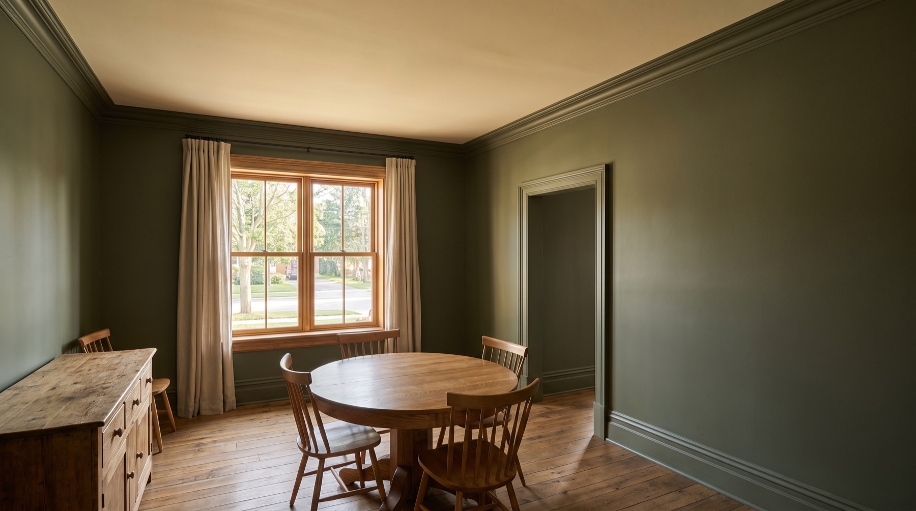 Finished dining room with deep olive walls and crisp ivory trim